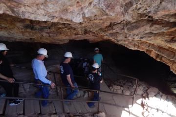 a group of people standing in front of a rock